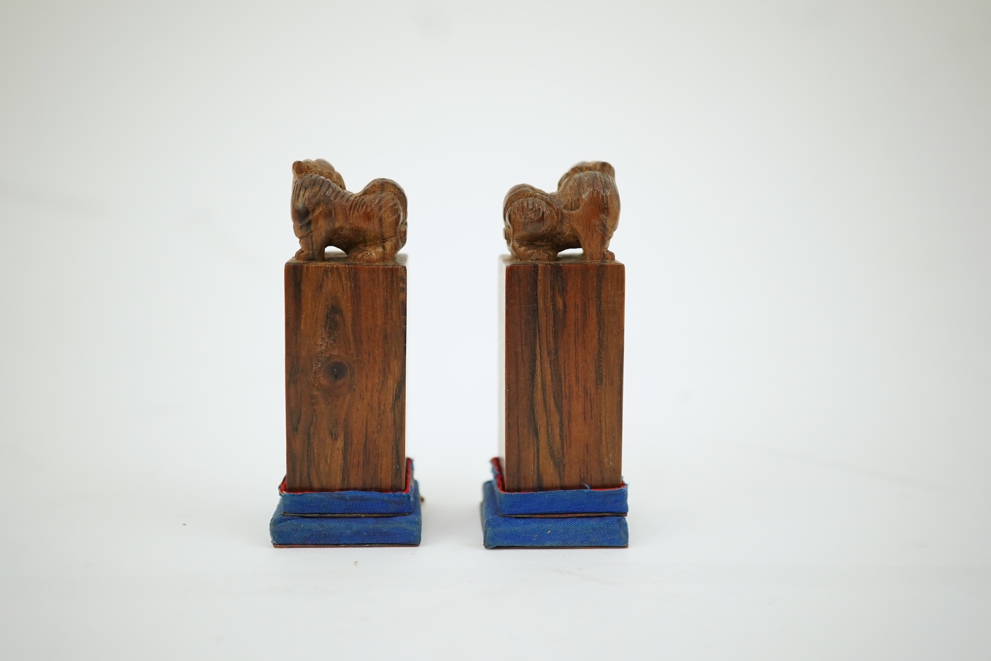 A cased pair of Chinese hardwood ‘lion-dog’ seals, early 20th century